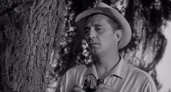 Movie still from “Cape Fear” (1962), directed by J. Lee Thompson – A black and white photo of a man holding a camera; Close Up shot, Low angle