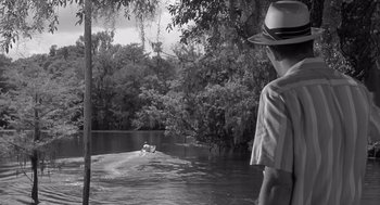 Movie still from “Cape Fear” (1962), directed by J. Lee Thompson – A man standing in front of a body of water; Wide shot, Over the shoulder angle