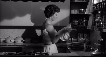 Movie still from “Cape Fear” (1962), directed by J. Lee Thompson – A black and white photo of a woman in a kitchen; Medium shot, Low angle