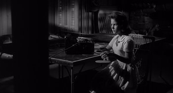 Movie still from “Cape Fear” (1962), directed by J. Lee Thompson – A young girl sitting at a table with an old radio; Medium shot, Low angle