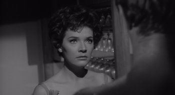 Movie still from “Cape Fear” (1962), directed by J. Lee Thompson – A black - and - white photo of a woman looking into a mirror; Close Up shot, Over the shoulder angle