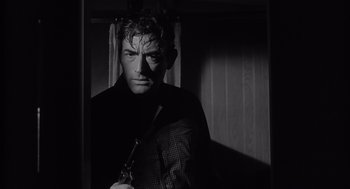 Movie still from “Cape Fear” (1962), directed by J. Lee Thompson – A black and white photo of a man holding a gun; Close Up shot, Over the shoulder angle