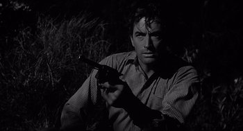Movie still from “Cape Fear” (1962), directed by J. Lee Thompson – A black and white photo of a man holding a gun; Close Up shot, Low angle