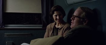 Movie still from “Capote” (2005), directed by Bennett Miller – A woman and a man sitting next to each other on a train; Medium shot, Over the shoulder angle