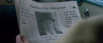 Movie still from “Capote” (2005), directed by Bennett Miller – A man in a hat is sitting on a newspaper; Extreme Close Up shot, High angle