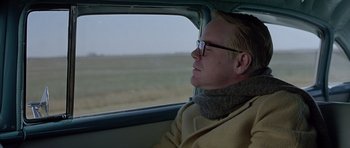 Movie still from “Capote” (2005), directed by Bennett Miller – A man sitting in the back of a car looking out the window; Close Up shot, Over the shoulder angle