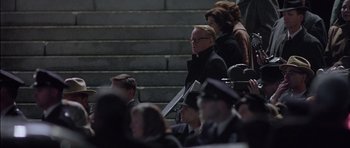 Movie still from “Capote” (2005), directed by Bennett Miller – A group of people sitting on steps in front of a building; Medium shot, Over the shoulder angle