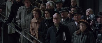 Movie still from “Capote” (2005), directed by Bennett Miller – A group of people standing next to each other on stairs; Medium shot, High angle
