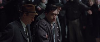 Movie still from “Capote” (2005), directed by Bennett Miller – A group of men standing next to each other in a crowd; Medium shot, High angle