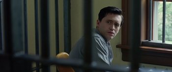 Movie still from “Capote” (2005), directed by Bennett Miller – A man sitting in a chair in front of a jail cell; Close Up shot, Over the shoulder angle