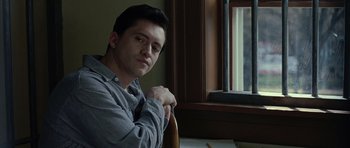 Movie still from “Capote” (2005), directed by Bennett Miller – A man sitting in front of a window with his arms crossed; Close Up shot, Low angle