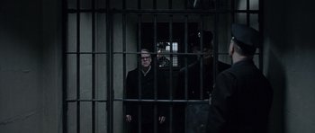 Movie still from “Capote” (2005), directed by Bennett Miller – A man standing in front of a jail cell; Medium shot, Low angle