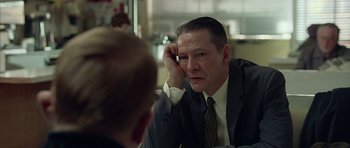 Movie still from “Capote” (2005), directed by Bennett Miller – A man wearing a suit and tie looking at a man in a suit; Close Up shot, Over the shoulder angle