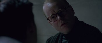 Movie still from “Capote” (2005), directed by Bennett Miller – A man wearing glasses looking at the camera; Close Up shot, Over the shoulder angle