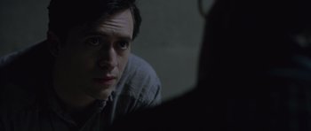 Movie still from “Capote” (2005), directed by Bennett Miller – A man sitting in front of a camera in a dark room; Close Up shot, Over the shoulder angle