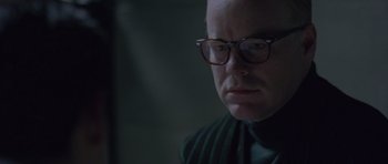 Movie still from “Capote” (2005), directed by Bennett Miller – A man wearing glasses and a green sweater; Close Up shot, Over the shoulder angle