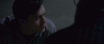 Movie still from “Capote” (2005), directed by Bennett Miller – A man sitting in front of a wall looking at something; Close Up shot, Over the shoulder angle