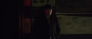 Movie still from “Capote” (2005), directed by Bennett Miller – A man wearing a hat standing in the dark; Close Up shot, Low angle