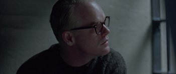 Movie still from “Capote” (2005), directed by Bennett Miller – A person wearing glasses and looking to the side; Close Up shot, Over the shoulder angle