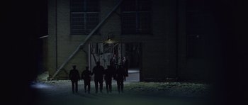 Movie still from “Capote” (2005), directed by Bennett Miller – A group of people standing in front of a building at night; Extreme Wide shot, High angle
