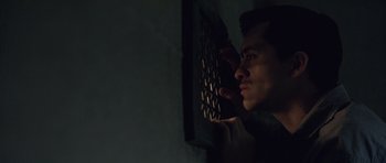 Movie still from “Capote” (2005), directed by Bennett Miller – A man looking out a window at night; Close Up shot, High angle