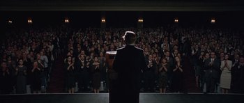 Movie still from “Capote” (2005), directed by Bennett Miller – A man standing in front of an audience at a podium; Wide shot, Low angle