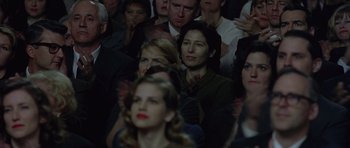 Movie still from “Capote” (2005), directed by Bennett Miller – A group of people sitting in a room watching a show; Medium shot, Over the shoulder angle