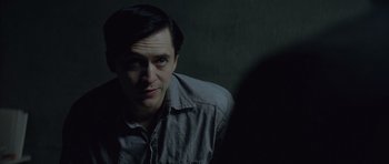 Movie still from “Capote” (2005), directed by Bennett Miller – A man in a gray shirt is looking at the camera; Close Up shot, Over the shoulder angle