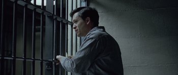 Movie still from “Capote” (2005), directed by Bennett Miller – A man standing in front of a metal gate; Close Up shot, High angle