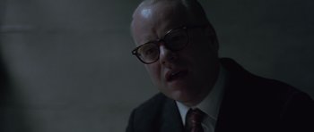 Movie still from “Capote” (2005), directed by Bennett Miller – An older man wearing glasses and a suit and tie; Close Up shot, Over the shoulder angle