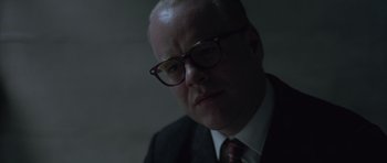Movie still from “Capote” (2005), directed by Bennett Miller – A person wearing a suit and glasses; Close Up shot, Over the shoulder angle