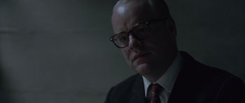 Movie still from “Capote” (2005), directed by Bennett Miller – A man in a suit and glasses looking at the camera; Close Up shot, Over the shoulder angle