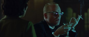 Movie still from “Capote” (2005), directed by Bennett Miller – A person wearing a suit and glasses; Close Up shot, Over the shoulder angle