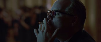 Movie still from “Capote” (2005), directed by Bennett Miller – A man with glasses is smoking a cigarette; Close Up shot, Over the shoulder angle