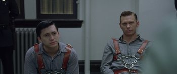 Movie still from “Capote” (2005), directed by Bennett Miller – A couple of men sitting next to each other in a room; Medium shot, Over the shoulder angle