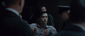 Movie still from “Capote” (2005), directed by Bennett Miller – A man in a gray shirt and brown suspenders; Medium shot, Over the shoulder angle