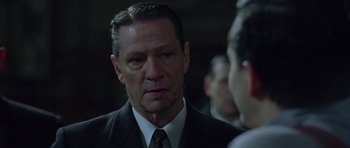 Movie still from “Capote” (2005), directed by Bennett Miller – A person wearing a suit and tie; Close Up shot, Over the shoulder angle