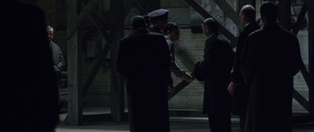 Movie still from “Capote” (2005), directed by Bennett Miller – A group of men standing next to each other; Wide shot, Over the shoulder angle
