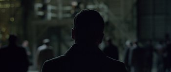Movie still from “Capote” (2005), directed by Bennett Miller – A man in a black suit is standing in the dark; Close Up shot, Over the shoulder angle