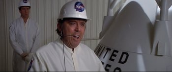 Movie still from “Capricorn One” (1977), directed by Peter Hyams – A man wearing a nasa hat and a headset; Medium shot, Low angle