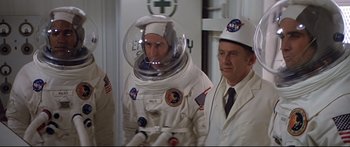 Movie still from “Capricorn One” (1977), directed by Peter Hyams – Two men in space suits are standing next to each other; Medium shot, Low angle