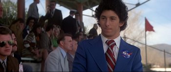 Movie still from “Capricorn One” (1977), directed by Peter Hyams – A man in a blue suit and a red tie; Close Up shot, Low angle