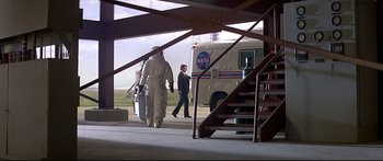 Movie still from “Capricorn One” (1977), directed by Peter Hyams – Two men walking down a ramp in front of a nasa bus; Wide shot, Low angle