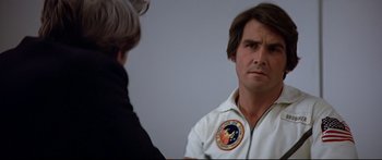 Movie still from “Capricorn One” (1977), directed by Peter Hyams – A man in a white shirt is talking to another man; Close Up shot, Over the shoulder angle