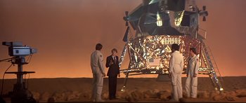 Movie still from “Capricorn One” (1977), directed by Peter Hyams – Three men standing in front of an american flag on the moon; Wide shot, Low angle