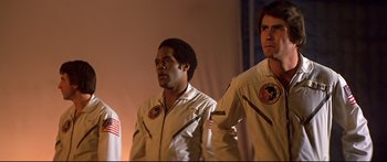 Movie still from “Capricorn One” (1977), directed by Peter Hyams – A couple of men standing next to each other; Medium shot, Low angle
