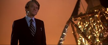 Movie still from “Capricorn One” (1977), directed by Peter Hyams – A man standing in front of an upside down ferris wheel; Medium shot, Low angle