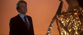 Movie still from “Capricorn One” (1977), directed by Peter Hyams – A man in a business suit standing in front of a building; Close Up shot, Low angle