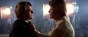 Movie still from “Capricorn One” (1977), directed by Peter Hyams – Two men are looking at one another in the dark; Close Up shot, Over the shoulder angle