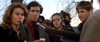 Movie still from “Capricorn One” (1977), directed by Peter Hyams – A man and a woman are being interviewed by reporters; Close Up shot, Over the shoulder angle